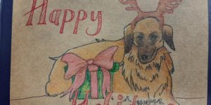 A "Happy Holidays" card with a dog with an antler headpiece sitting with a gift box.