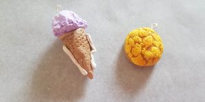 Purple ice cream on napkin-wrapped waffle cone (left) and pineapple bun (right) polymer clay charms.